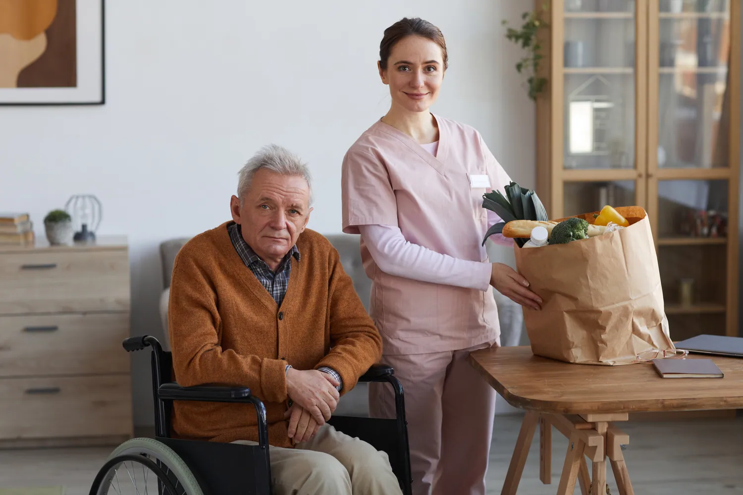 Symbolbild: Pflegekraft begleitet einen Senioren und bringt die Einkäufe