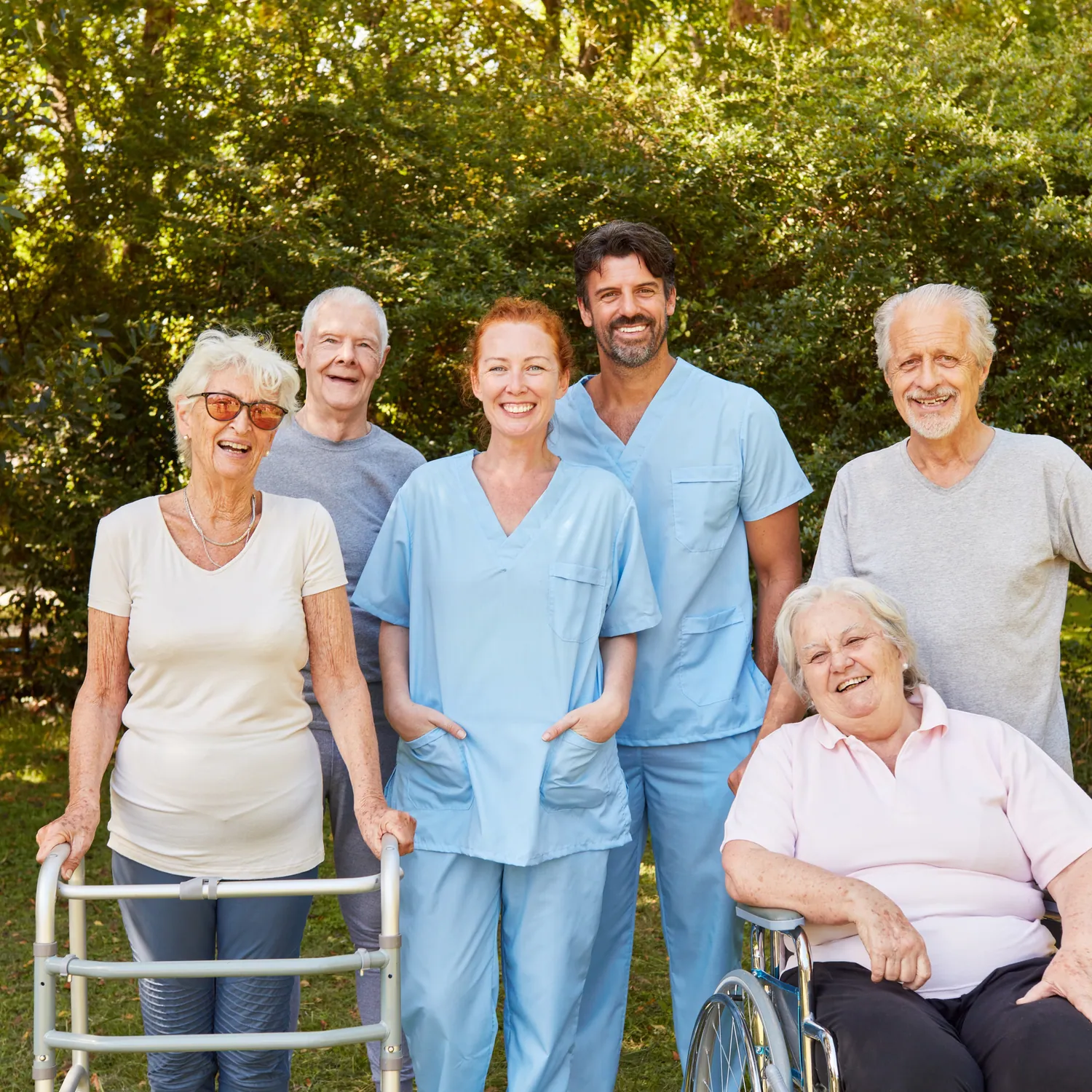 Symbolbild: Gruppe von Seniorinnen und Senioren mit Pflegekräften im Freien